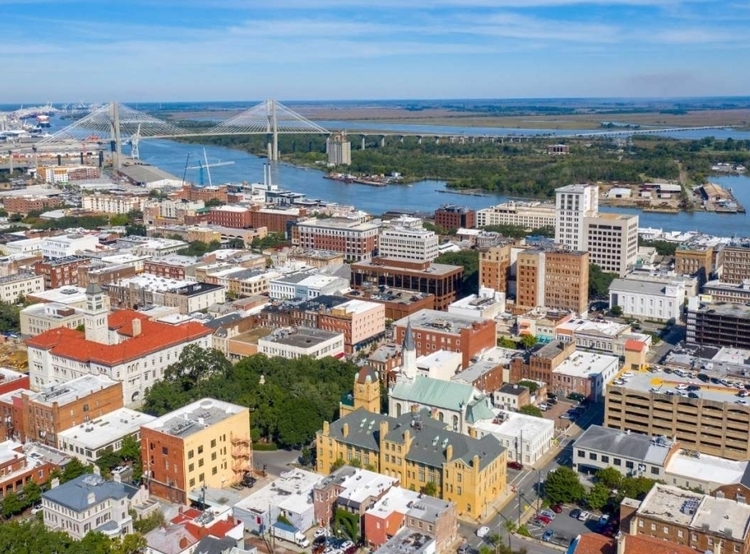 An ariel view of Savannah showcasing the rooftops, large drawstring bridge, and river